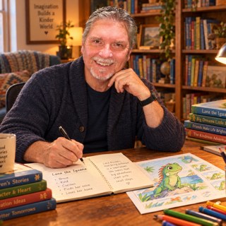 Bob Vernon, author of An Iguana Named Lana and Huffin the Puffin, writing in a notebook at his desk